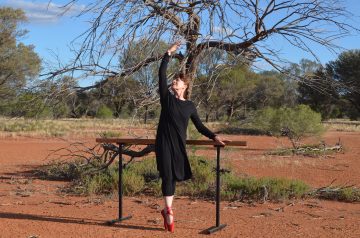 Image of a dancer wearing red pointe shoes in red dust. Photograph taken whilst filming in the outback of SW Queensland.